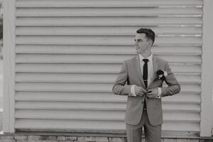 Portrait of a handsome young groom on an autumn day outdoors in an elegant suit. Outdoor photo. Handsome man in a business suit. photo