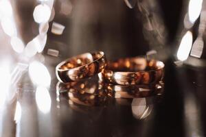 elegante Boda anillos en fumar. promesas compromiso. lujo matrimonio y Boda accesorio concepto. dos Boda anillos y un Boda invitación. foto