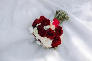 a wedding bouquet of red roses stands in nature photo