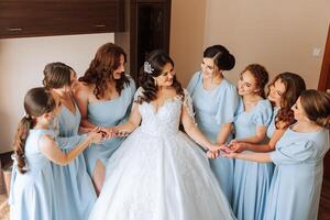 retrato de el novia con su amigos. elegante y elegante novia con su amigos en pareo vestidos en el habitación en el Mañana. muchos hermosa muchachas en uno foto. foto