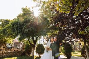 Boda Pareja en un caminar en el otoño parque. el novia en un hermosa blanco vestido. amor y relación concepto. novio y novia en naturaleza al aire libre foto