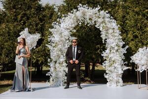 A female wedding presenter giving a speech and the groom photo