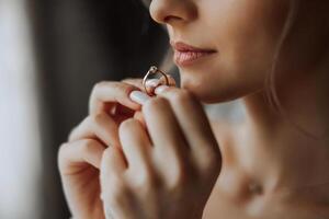 Close-up of an elegant diamond ring on a woman's finger with a modern manicure, sunlight. Love and wedding concept. Soft and selective focus. photo