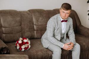 novio con un ramo de flores de rosas, novio con ramo, novio con un Boda ramo, un joven hombre con un Boda ramo de flores en su mano, bien adecuado hombre foto