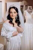 portrait of an incredibly beautiful girl bride in a white robe in the bedroom, the bride poses in the morning before the wedding ceremony. photo