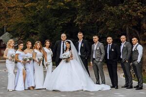 Wedding photo session in nature. The bride and groom kiss and their friends