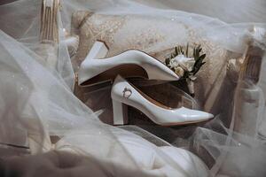 Bride's wedding ring on high-heeled shoes, women's perfume, wedding glasses. Wedding details. High quality photo