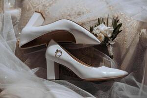 Bride's wedding ring on high-heeled shoes, women's perfume, wedding glasses. Wedding details. High quality photo