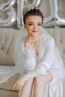 portrait of an incredibly beautiful girl bride in a white robe in the bedroom, the bride poses in the morning before the wedding ceremony. photo