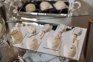 almendra galletas, dulce pasteles para un Boda banquete. un delicioso recepción, un lujoso ceremonia. mesa con dulces y postres delicioso vistoso francés postres en un plato o mesa. caramelo bar. foto