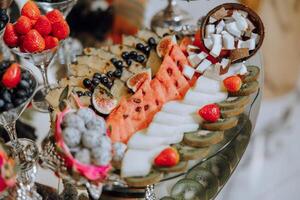 un banquete mesa lleno de frutas y bayas, un surtido de dulces plátanos, uvas, piñas. Fruta composiciones para el día festivo. foto