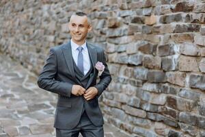 retrato de un hermoso joven novio en un otoño día al aire libre en un elegante traje. al aire libre foto. hermoso hombre en un negocio traje. foto