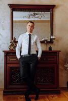 Portrait of smiling successful Caucasian man in formal suit, posing in room, happy young male boss or CEO looking at camera, showing confidence and strength, leadership concept photo