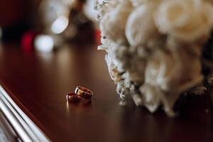 Stylish wedding rings on a wooden table. Promises engagement. Luxury marriage and wedding accessory concept. two wedding rings and a wedding invitation. photo