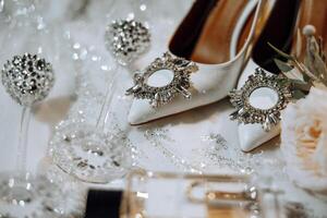 Bride's wedding ring on high-heeled shoes, women's perfume, wedding glasses. Wedding details. High quality photo