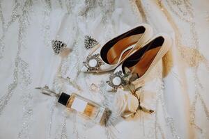 Bride's wedding ring on high-heeled shoes, women's perfume, wedding glasses. Wedding details. High quality photo