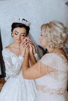 A beautiful and happy mother and her daughter, the bride, are standing next to each other. The best day for parents. Tender moments at the wedding. photo