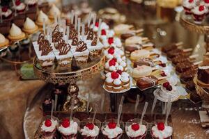 almendra galletas, dulce pasteles para un Boda banquete. un delicioso recepción, un lujoso ceremonia. mesa con dulces y postres delicioso vistoso francés postres en un plato o mesa. caramelo bar. foto