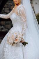 Portrait. A brunette bride in a dress and a veil, with a chic crown, poses with a bouquet. Silver jewelry. Beautiful makeup and hair. Autumn wedding. celebration photo