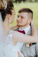 The bride and groom look at each other on their wedding day. Over the shoulder shot of a wedding couple. Tenderness and love in the eyes. photo