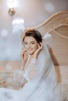 portrait of an incredibly beautiful girl bride in a white robe in the bedroom, the bride poses in the morning before the wedding ceremony. photo