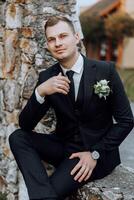 retrato de un hermoso joven novio en un otoño día al aire libre en un elegante traje. al aire libre foto. hermoso hombre en un negocio traje. foto