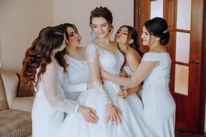 retrato de el novia con su amigos. elegante y elegante novia con su amigos en pareo vestidos en el habitación en el Mañana. muchos hermosa muchachas en uno foto. foto