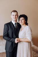 mother helps her adult son prepare for the wedding ceremony. An emotional and touching moment at a wedding. A mother hugs her son photo