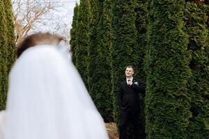 The moment of the first meeting of the bride and groom with a wedding bouquet, the bride goes to her lover in nature under the autumn sun. photo