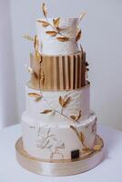 A large luxurious multi-tiered wedding cake in the banquet hall. Wedding dessert under the evening light. Wedding decor. photo