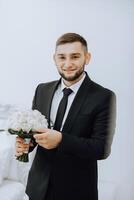 novio con un ramo de flores de rosas, novio con ramo, novio con un Boda ramo, un joven hombre con un Boda ramo de flores en su mano, bien adecuado hombre foto