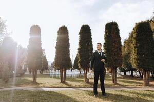 retrato de un hermoso joven novio en un otoño día al aire libre en un elegante traje. al aire libre foto. hermoso hombre en un negocio traje. foto