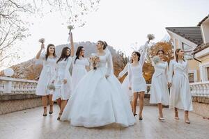 Wedding photography. A brunette bride in a white dress with a bouquet and her brunette girlfriends photo