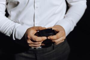 closeup of caucasian man putting on his belt. A stylish man puts on a leather belt close-up. Fashion photo