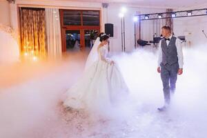 the first dance at the wedding of the bride and groom in an elegant restaurant with great lighting and atmosphere. Heavy smoke photo