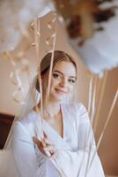 hermosa morena novia en un blanco vestido, túnica, participación blanco gel pelotas en su manos y disfrutando su Boda día en su habitación. Boda fotografía. foto