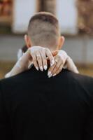 Brides hand arm around groom. Wedding day moment. Bride holding grooms shoulder, in love couple on wedding day together. Bride and groom. flowers and rings. Brides hand holding groom. photo