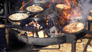 hd vídeo do cozinhando creps com gordo e carne de porco torresmo dentro fundida ferro panelas sobre Alto aquecer. video