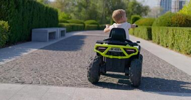 giovane ragazzo equitazione giocattolo auto nel parco video