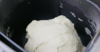 Bread dough in a black bread machine pan. Close-up shot of the baking process. video