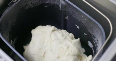 Bread dough in a black bread machine pan. Close-up shot of the baking process. video