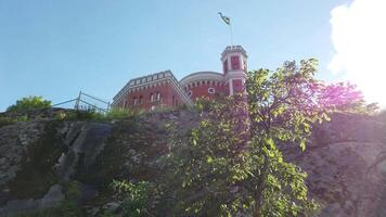 The Swedish flag flies over a historic building in Stockholm on a sunny day. video