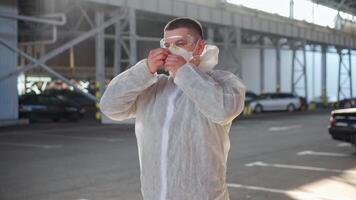 uma homem é vestindo uma protetora terno e mascarar dentro a esvaziar estacionamento muitos video