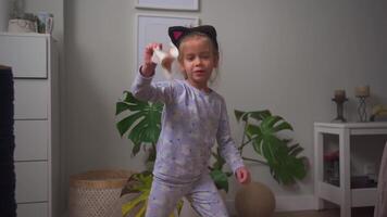 a little girl with cat ears headband is picking up a handkerchief and playing with it video