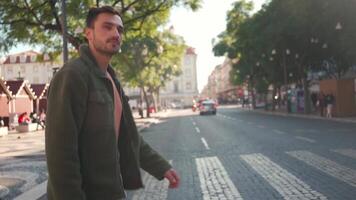 uma homem dentro uma verde Jaqueta cruzando a rua às a zebra Cruz video