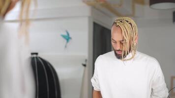 a man with a beard and a gold hair piece is standing in front of a mirror video