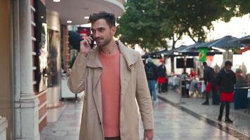 a man in a coat is talking on a cell phone while walking down the street video