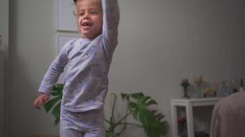 a little girl with cat ears headband is dancing and jumping video