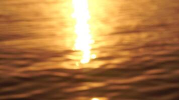 Sea water surface sunset. Low angle view over golden sea water. Sun glare. Abstract nautical summer ocean nature. Holiday, vacation and travel concept. Nobody. Slow motion. Weather and climate change video