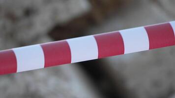 Red and white warning tape swinging in the wind. Protection sign. Don't cross the line. Red White caution tape pole fencing is protects for No entry. Backdrop without people, empty street. video